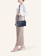 Model wearing the 21 Crossbody Bag, styled as a crossbody for a chic everyday look.