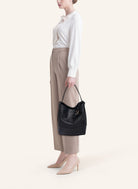 Model wearing the 51 Large Bucket Bag, styled as a sophisticated everyday statement piece.
